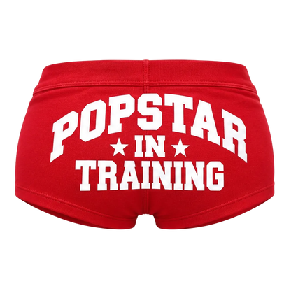 Red shorts with white POPSTAR IN TRAINING lettering, back view